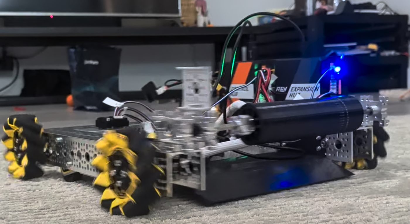 Our prototype robot base: an aluminum chassis on yellow-and-black mecanum wheels, with its control electronics and wiring on top